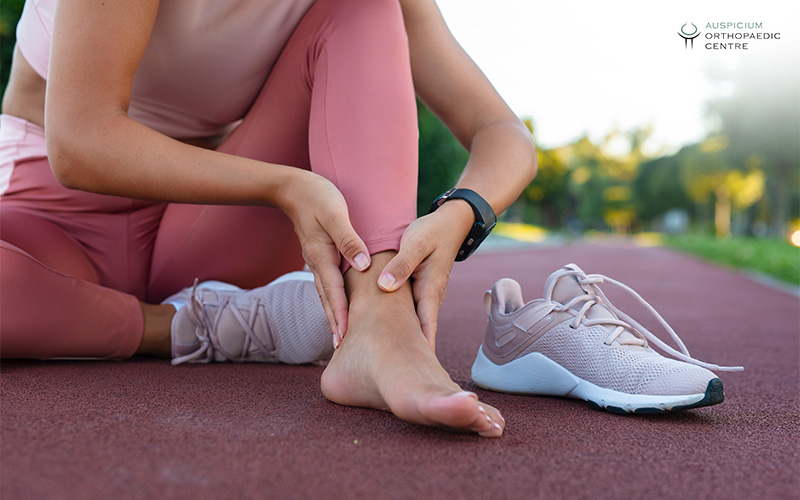 A runner clutching their painful ankle.