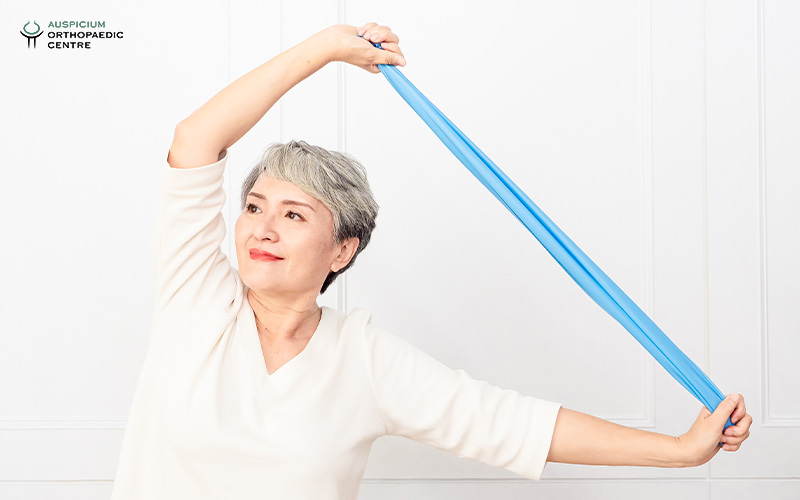 Woman doing shoulder exercises with a resistance band.